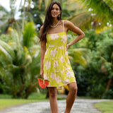 woman wearing a bright green tie back mini dress with orchid print