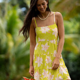 woman wearing a bright green tie back mini dress with orchid print