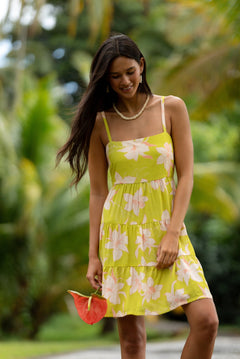 woman wearing a bright green tie back mini dress with orchid print