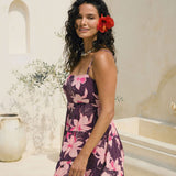 woman wearing dark purple mini dress with tie back detail with orchid print