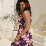 woman wearing dark purple mini dress with tie back detail with orchid print