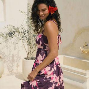 woman wearing dark purple mini dress with tie back detail with orchid print