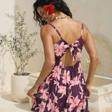 woman wearing dark purple mini dress with tie back detail with orchid print