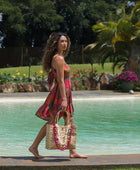 woman with brown hair wearing a colorful mini dress with tropical lei print