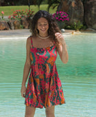 woman with brown hair wearing a colorful mini dress with tropical lei print
