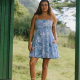 woman with brown hair wearing blue paniolo print mini dress with tie back detail