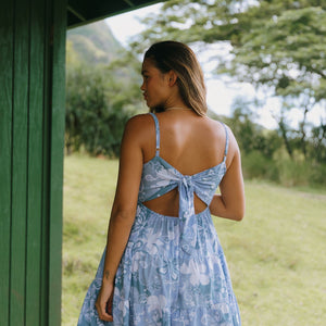 woman with brown hair wearing blue paniolo print mini dress with tie back detail