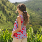 woman with brown hair wearing a scrunchie with periwinkle background and bright red hibiscus print.