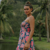 woman with brown hair wearing a navy strapless mini dress with ruffle hem and bright pink hibiscus print