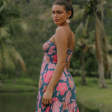 woman with brown hair wearing a navy strapless mini dress with ruffle hem and bright pink hibiscus print