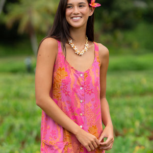 woman wearing a pink tie back romper with lei print