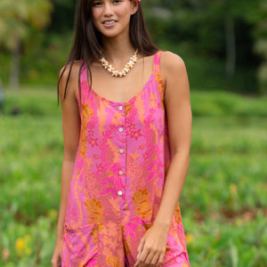 woman wearing a pink tie back romper with lei print