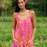 woman wearing a pink tie back romper with lei print