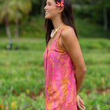 woman wearing a pink tie back romper with lei print