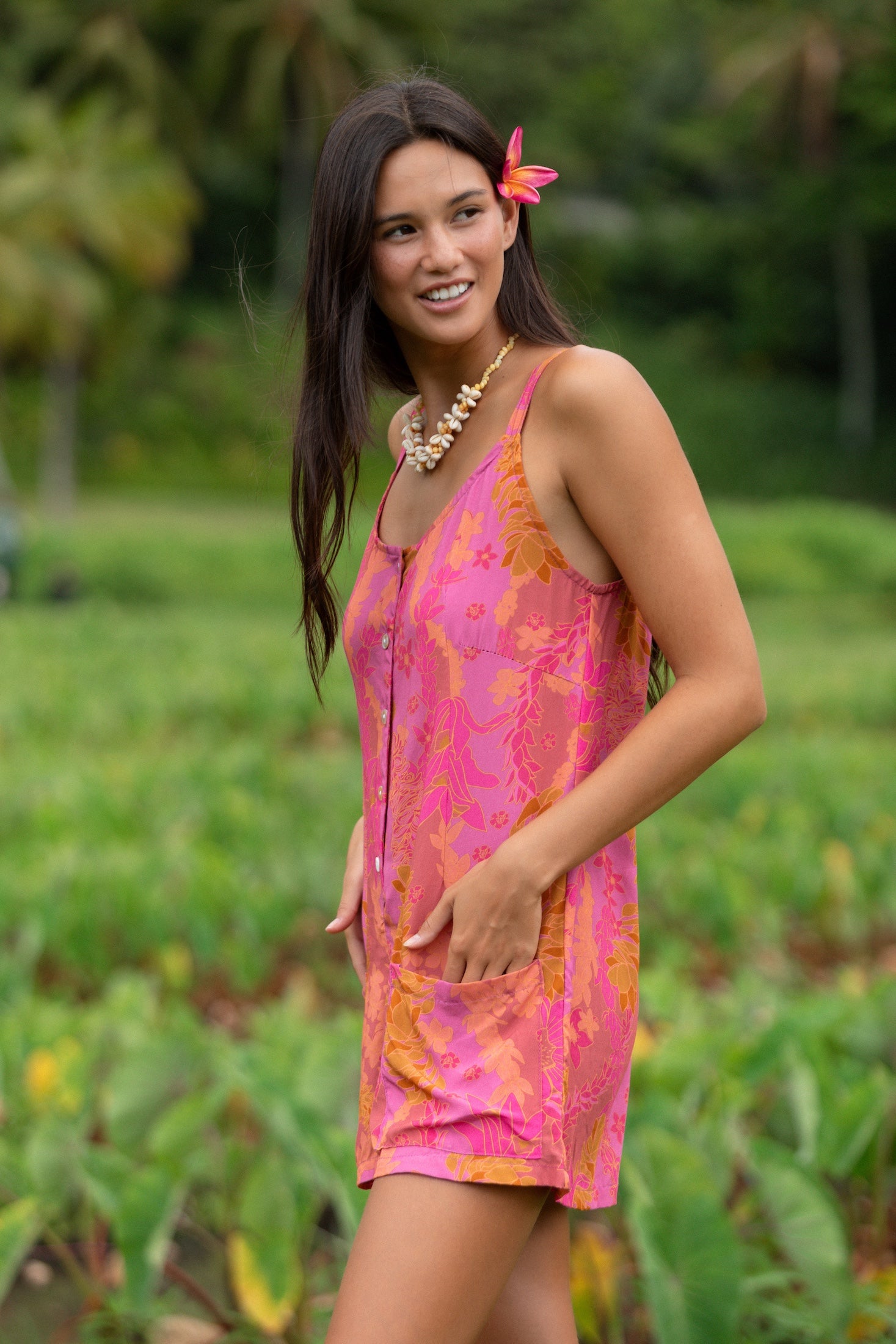 woman wearing a pink tie back romper with lei print