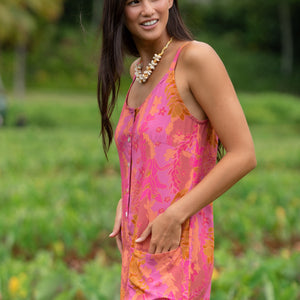 woman wearing a pink tie back romper with lei print