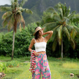 woman with brown hair wearing teal flowy pants with orange and pink foral print