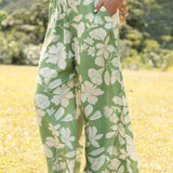 woman wearing green matching top and pant set with native Hawaiian plants 