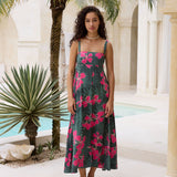 woman with brown hair wearing a dark green thin strap dress with fern and ginger print