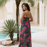 woman with brown hair wearing a dark green thin strap dress with fern and ginger print