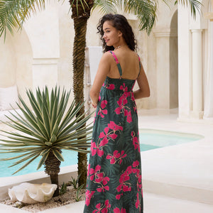 woman with brown hair wearing a dark green thin strap dress with fern and ginger print