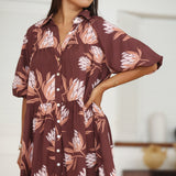 woman wearing brown button up puffy sleeve baby doll dress with protea pattern