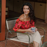 woman wearing versatile smocked top with off the shoulder on the shoulder sleeves in a vibrant retro pink pua print