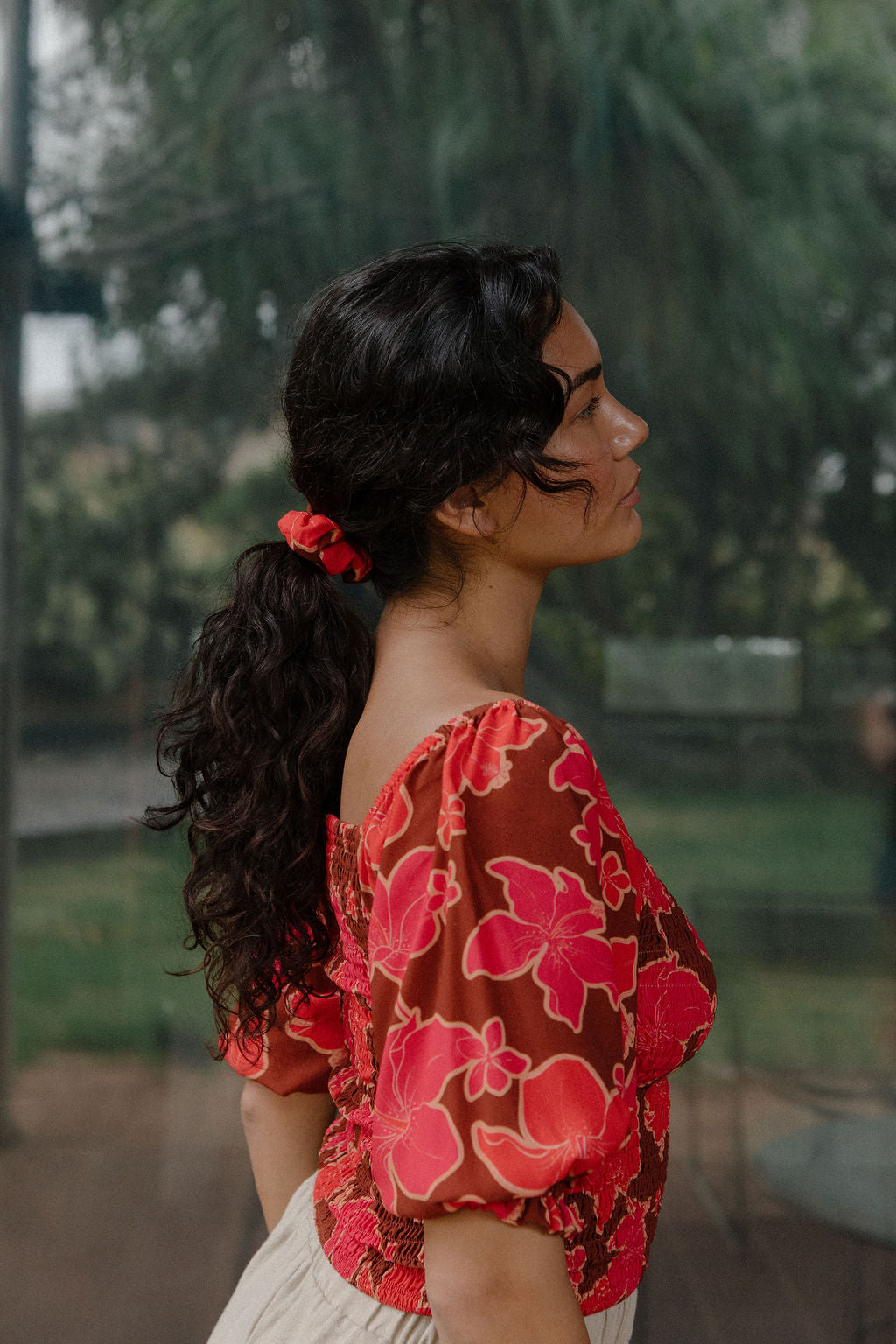 woman wearing versatile smocked top with off the shoulder on the shoulder sleeves in a vibrant retro pink pua print