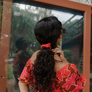 woman wearing versatile smocked top with off the shoulder on the shoulder sleeves in a vibrant retro pink pua print