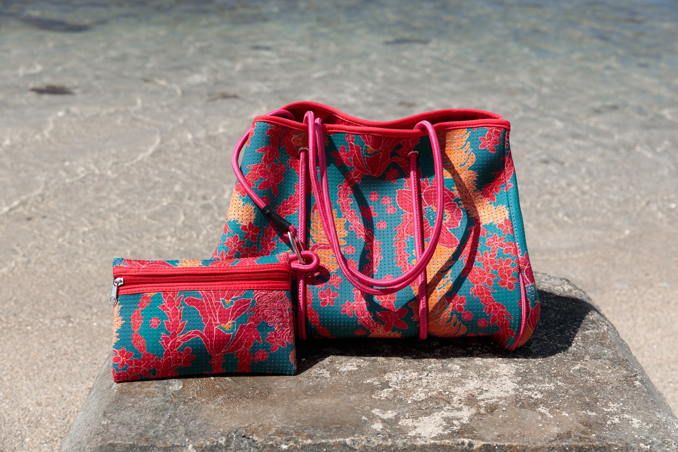 large rich blue neoprene tote bag with red and orange lei pattern
