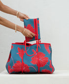 large neoprene tote bag and matching pouch in a bright teal and red mao flower pattern