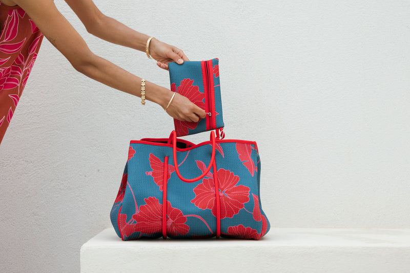large neoprene tote bag and matching pouch in a bright teal and red mao flower pattern