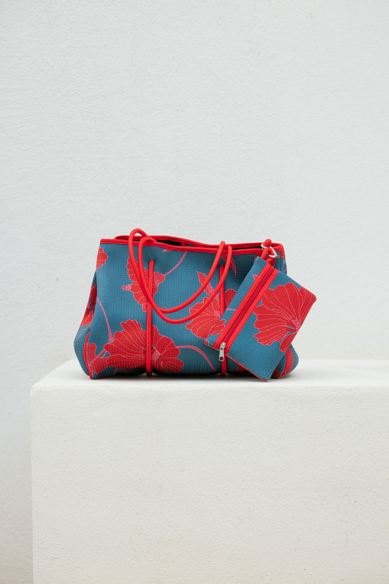large neoprene tote bag and matching pouch in a bright teal and red mao flower pattern
