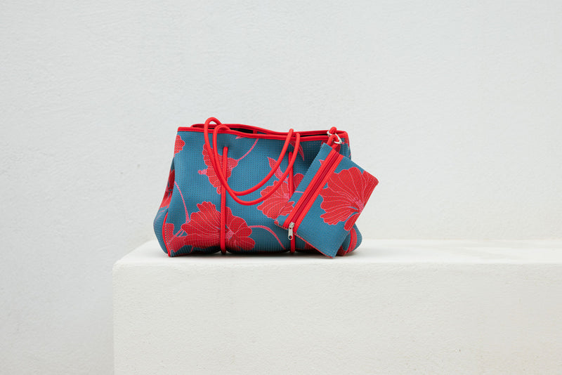 large neoprene tote bag and matching pouch in a bright teal and red mao flower pattern