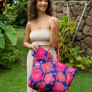 woman carrying large dark navy blue everyday tote bag with rope straps, detachable mini pouch, and bright pink hibiscus print