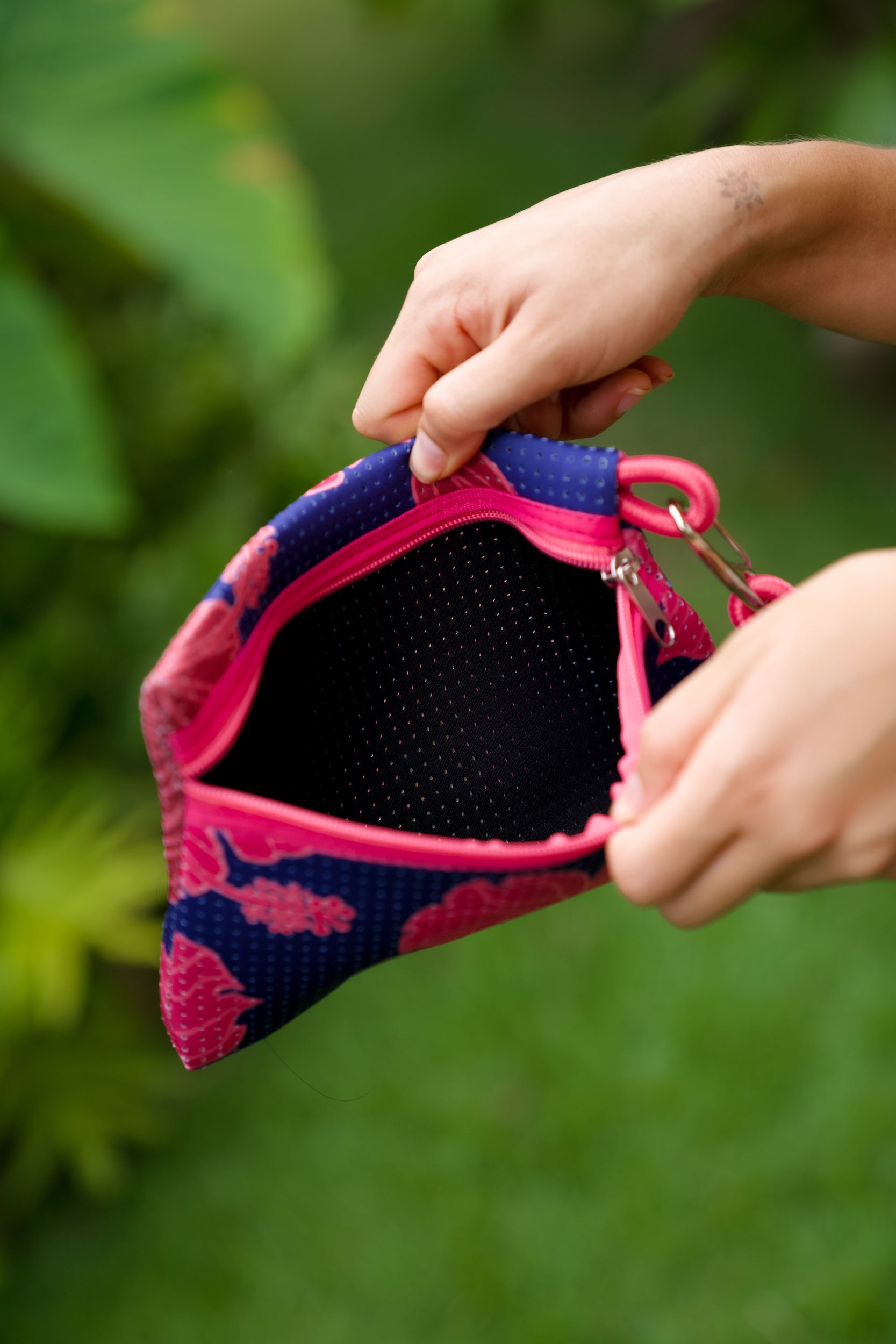 woman carrying large dark navy blue everyday tote bag with rope straps, detachable mini pouch, and bright pink hibiscus print