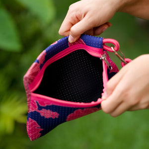 woman carrying large dark navy blue everyday tote bag with rope straps, detachable mini pouch, and bright pink hibiscus print