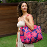woman carrying large dark navy blue everyday tote bag with rope straps, detachable mini pouch, and bright pink hibiscus print