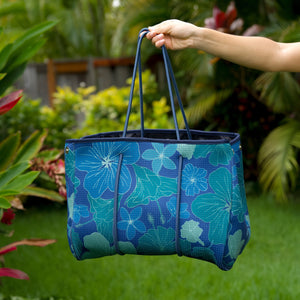 woman carrying large dark navy blue everyday tote bag with rope straps, detachable mini pouch, and blue/green flower print