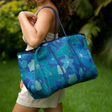 woman carrying large dark navy blue everyday tote bag with rope straps, detachable mini pouch, and blue/green flower print