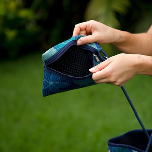 woman carrying large dark navy blue everyday tote bag with rope straps, detachable mini pouch, and blue/green flower print