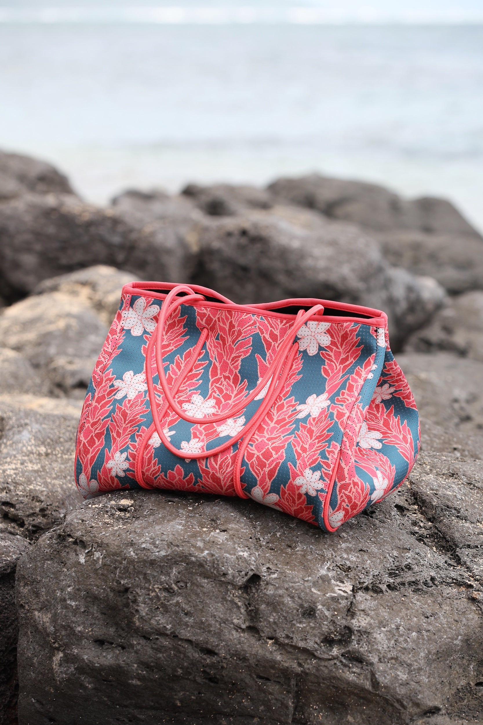 everyday tote bag made from neoprene featuring tiare and ginger flower on a teal background