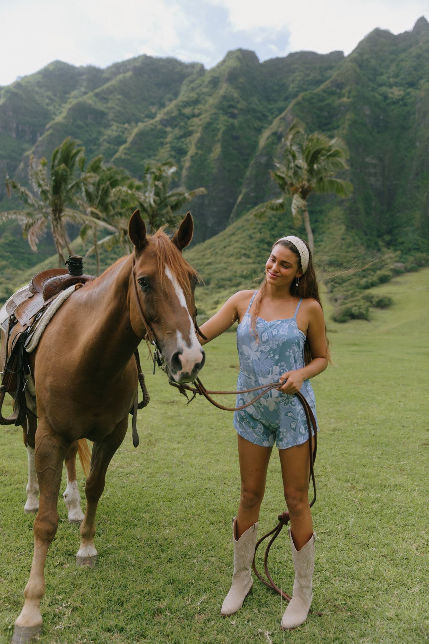 woman with brown hair wearing blue paniolo print overall style romper with bandeau
