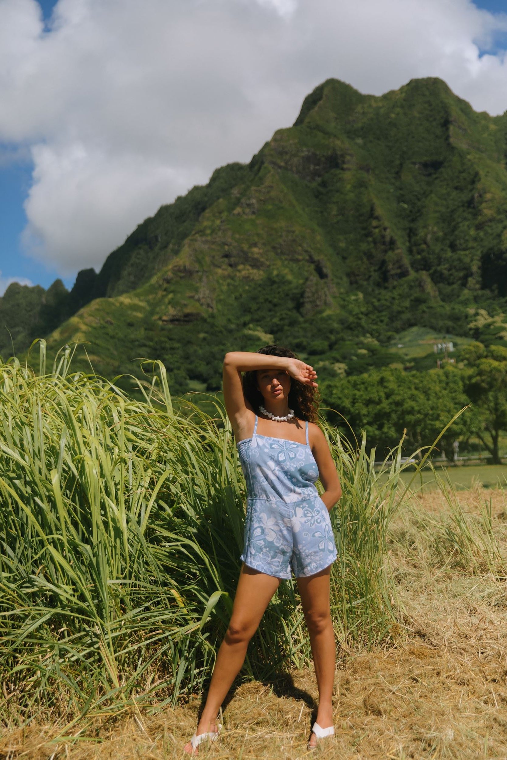 woman with brown hair wearing blue paniolo print overall style romper with bandeau
