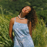 woman with brown hair wearing blue paniolo print overall style romper with bandeau