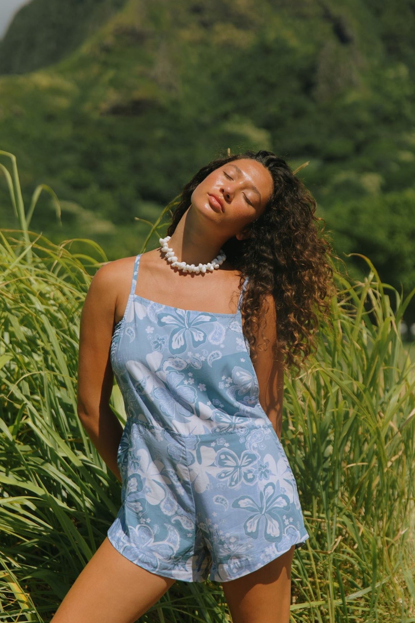 woman with brown hair wearing blue paniolo print overall style romper with bandeau