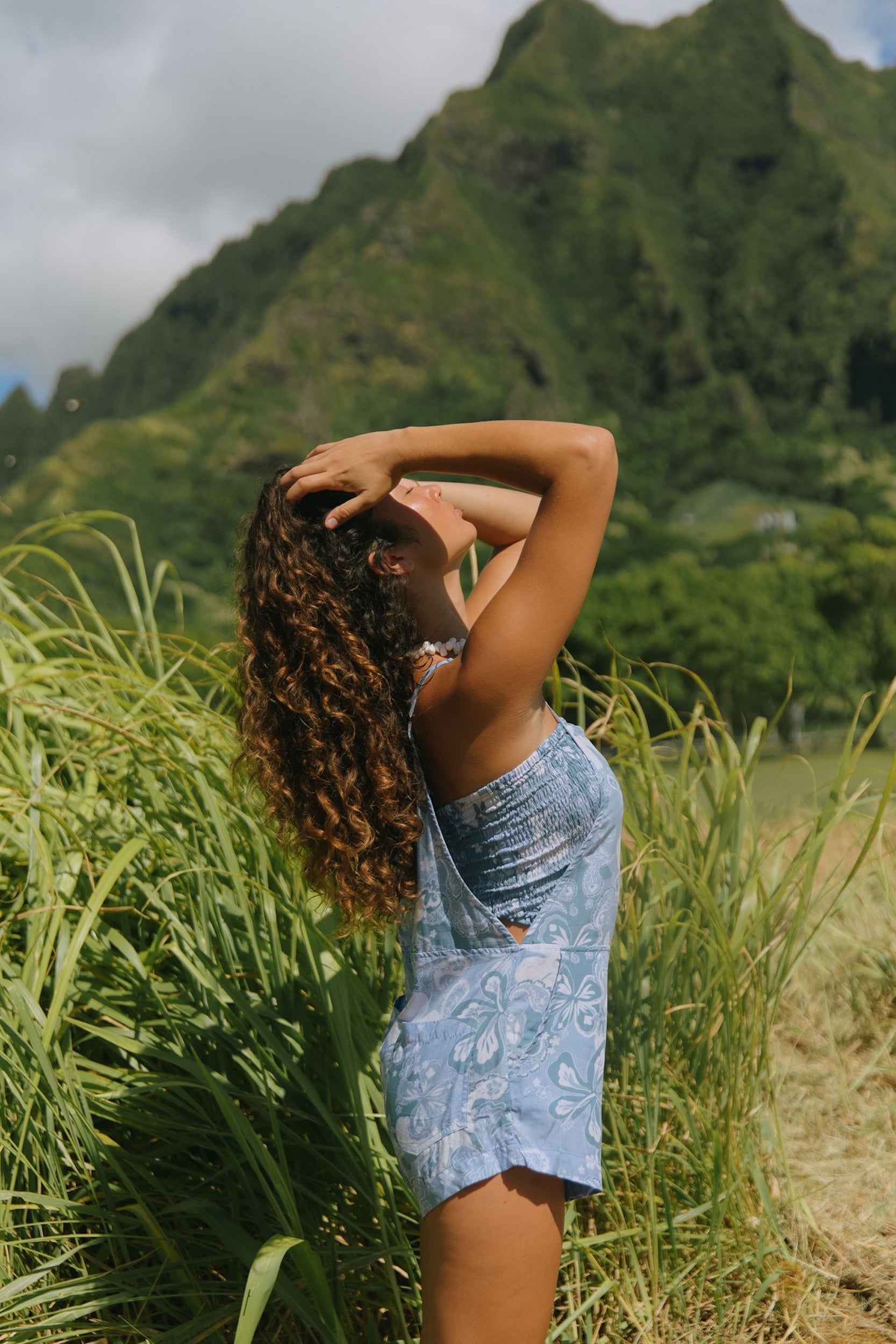 woman with brown hair wearing blue paniolo print overall style romper with bandeau