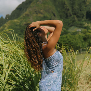woman with brown hair wearing blue paniolo print overall style romper with bandeau