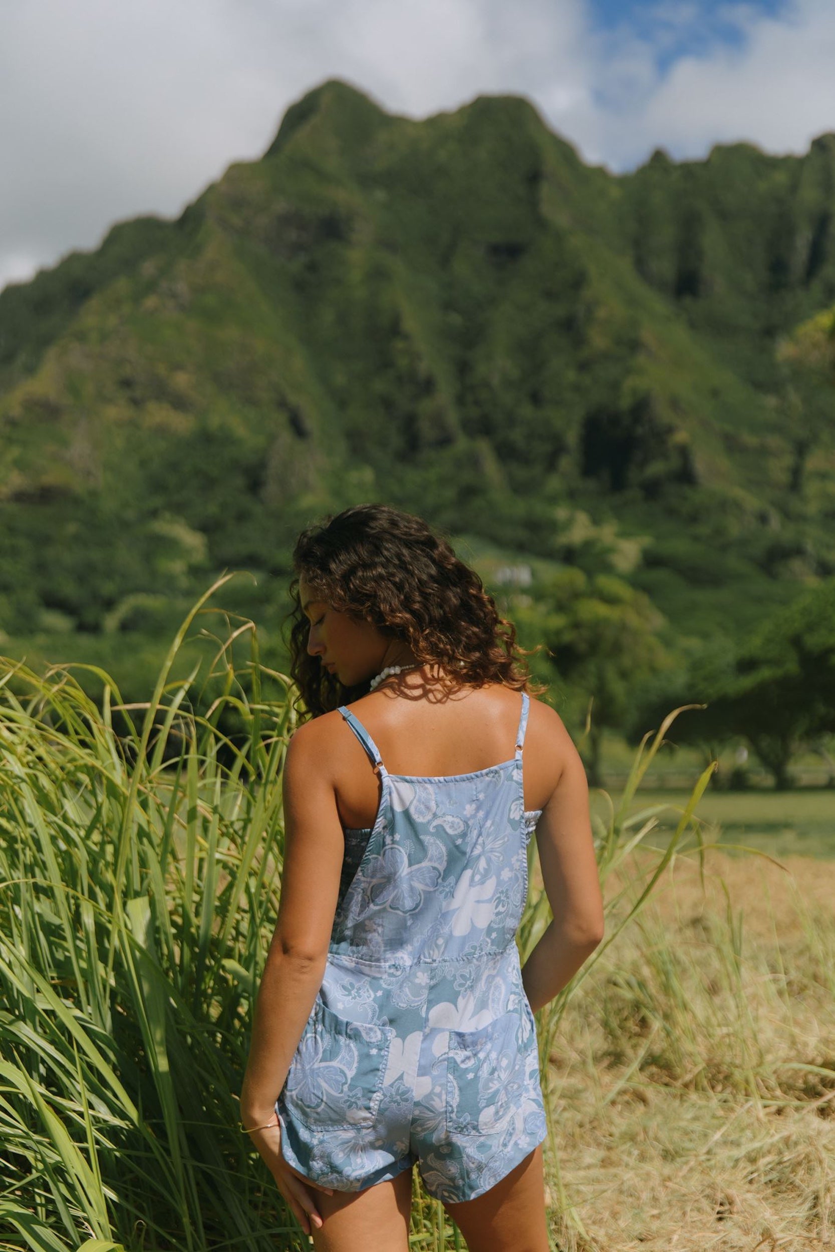 woman with brown hair wearing blue paniolo print overall style romper with bandeau