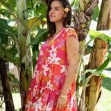 woman with brown hair wearing a pink short sleeve tiered mini dress with retro flower print